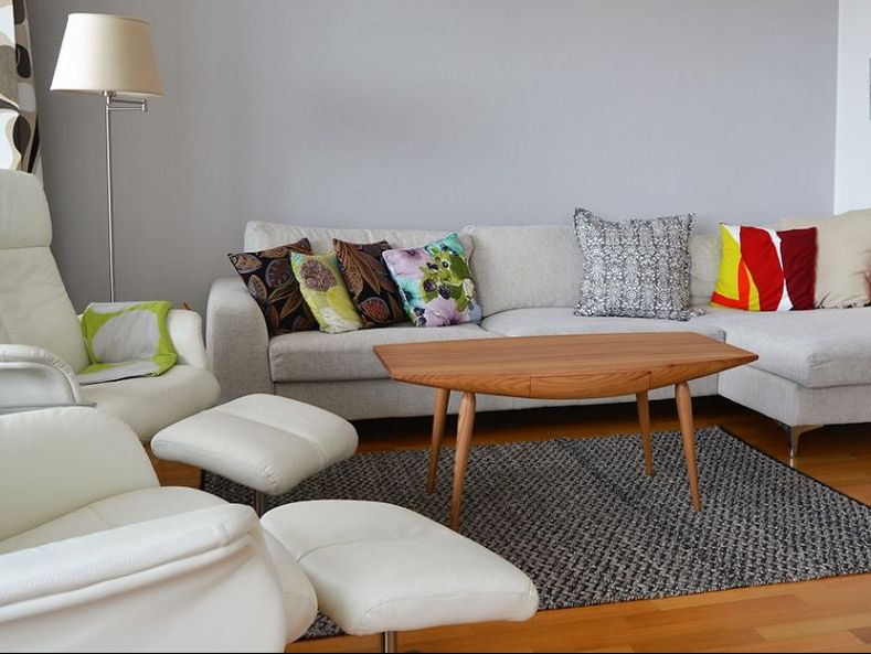 Vaalea olohuone ja keskellä huonetta puinen sohvapöytä